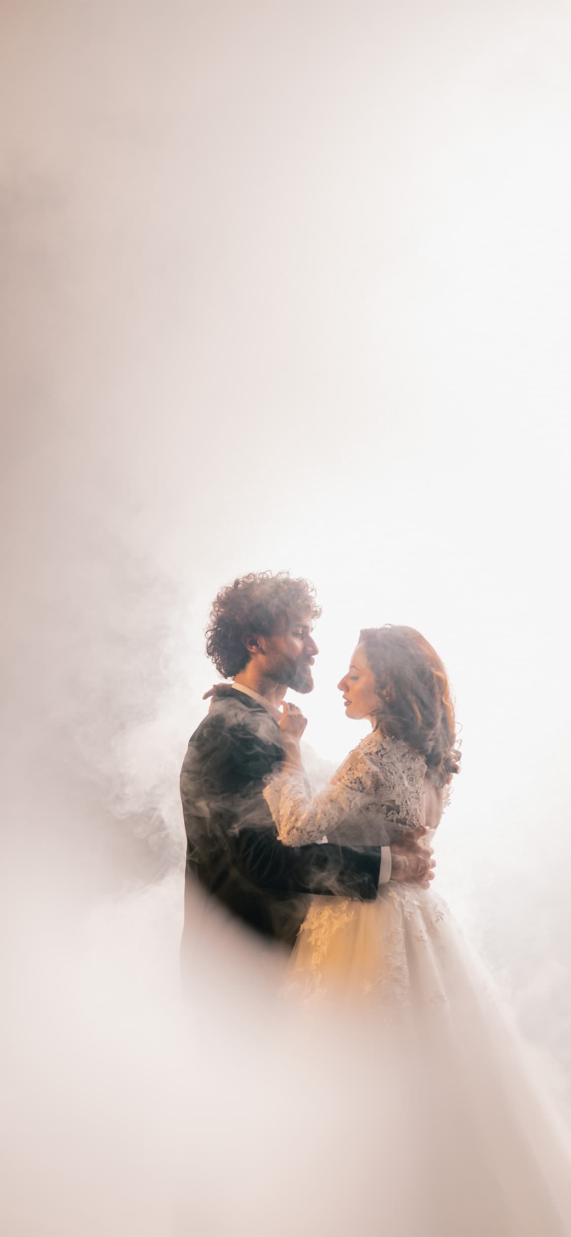 Bride and groom silhouetted against golden evening light